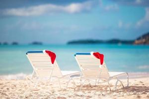 gros plan chapeau de père noël sur une chaise sur une plage blanche tropicale photo