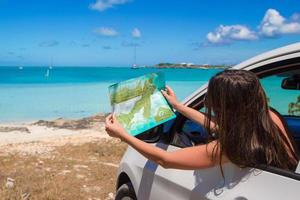 jeune femme attirante avec une grande carte de l'île dans la voiture photo