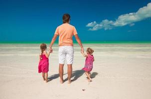 vue arrière du jeune père et de ses deux adorables filles en vacances exotiques photo