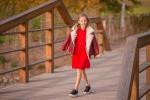 portrait d'une adorable petite fille au bouquet de feuilles jaunes à l'automne photo