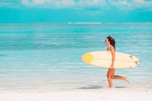 belle surfeuse prête à surfer dans la mer turquoise, sur une planche à pagaie en vacances exotiques photo