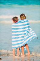 adorables petites filles enveloppées dans une serviette à la plage tropicale photo