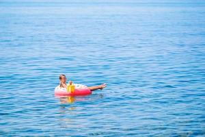 adorable fille sur un matelas pneumatique gonflable dans la mer photo