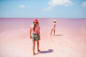 filles sur un lac salé rose par une journée d'été ensoleillée. photo