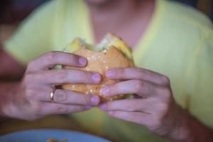 Close up burger dans les mains de l'homme sur le petit déjeuner photo