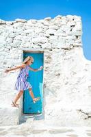 fille en robes bleues s'amusant à l'extérieur dans les rues de mykonos photo