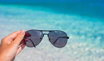 gros plan de lunettes de soleil sur la plage tropicale photo