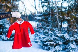 robe de père noël rouge pour enfant dans une forêt de sapins enneigés photo