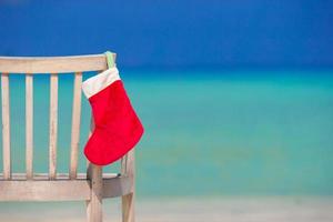 bas de noël rouge sur une chaise au fond d'un café en plein air la mer photo