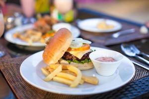 burger et frites sur plaque blanche pour le déjeuner photo