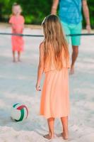 adorable petite fille jouant avec un ballon sur la plage. sports d'été pour enfants en plein air sur l'île des caraïbes