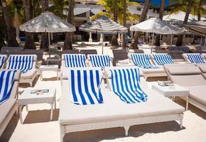 chaises de plage dans un complexe exotique sur une plage de sable blanc parfaite photo