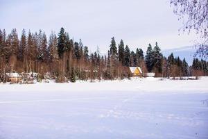 paysage d'hiver avec une petite maison dans la forêt photo