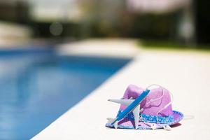 modèle d'avion et chapeau de paille violet près de la piscine en été photo