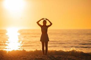 Happy teen girl profitez de vacances à la plage tropicale au coucher du soleil photo