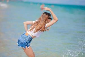 adorable adolescente sur la plage profite de ses vacances d'été photo