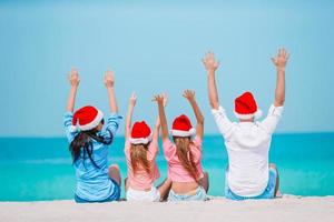 famille heureuse avec deux enfants en bonnet de noel en vacances d'été photo