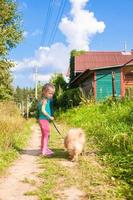 petite fille marchant avec son chien en laisse photo