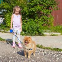 petite fille marchant avec son chien en laisse photo