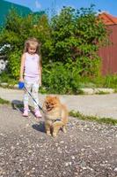 petite fille marchant avec son chien en laisse photo