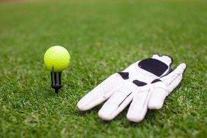 balle et gant d'équipement de golf sur l'herbe verte