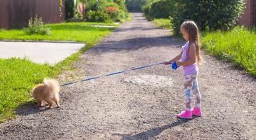 petite fille marchant avec son chien en laisse photo