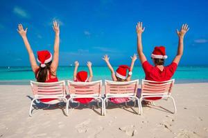 famille heureuse avec deux enfants en bonnet de noel en vacances d'été photo