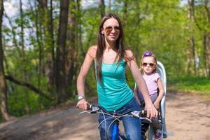 jeune mère et jolie petite fille faisant du vélo ensemble photo