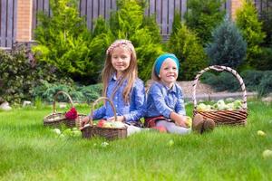 deux petites filles heureuses avec une grande récolte d'automne de tomates photo