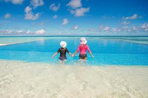 adorables petites filles jouant dans une piscine extérieure en vacances photo