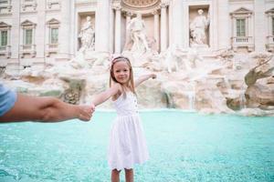 adorable petite fille fond fontaine de trevi, rome, italie. photo