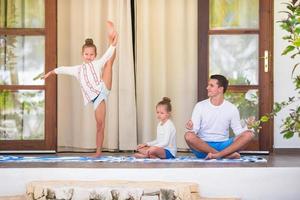 jeune famille faisant du yoga et méditant sur la terrasse photo