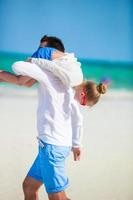 famille heureuse s'amusant sur la plage tropicale blanche photo