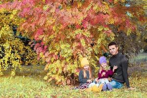 famille heureuse dans le parc d'automne à l'extérieur photo