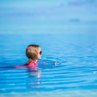 petite fille adorable heureuse dans la piscine extérieure photo