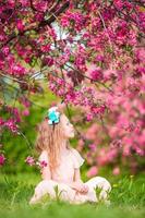 adorable petite fille dans un jardin de pommiers en fleurs le beau jour du printemps photo