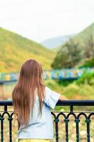 fille heureuse au chapeau sur le talus d'une rivière de montagne dans une ville européenne. photo