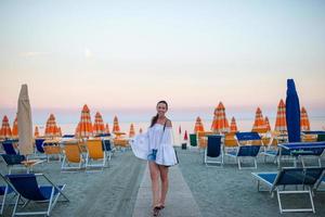 jeune femme appréciant la journée d'été sur la plage au coucher du soleil. vacances à la plage en europe photo