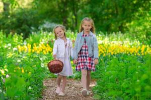 petites filles adorables marchant dans le jardin luxuriant de tulipes photo