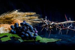 pain aux raisins de blé et couronne d'épines sur fond noir comme symbole du christianisme photo