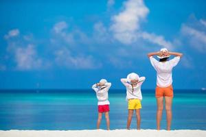 adorables petites filles et jeune mère sur la plage blanche tropicale photo