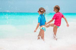 adorables petites filles s'amusent sur la plage blanche pendant les vacances photo