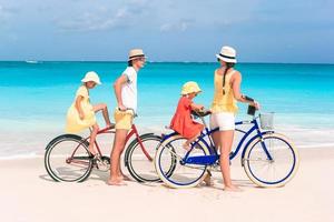 famille avec un vélo sur la plage tropicale photo