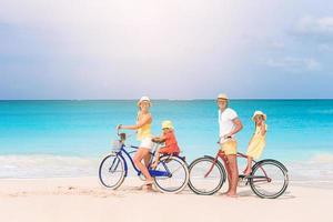 famille avec un vélo sur la plage tropicale photo