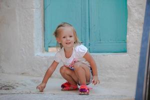 petite belle fille se promène dans les vieilles rues du village grec emporio photo