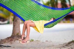 adorable petite fille en vacances tropicales se détendre dans un hamac photo