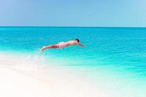jeune homme plongeant dans la mer turquoise photo