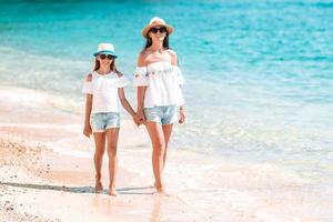 belle mère et fille à la plage profitant des vacances d'été. photo