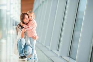 maman heureuse et petite fille avec carte d'embarquement à l'aéroport photo