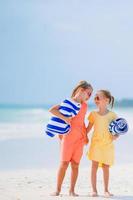 les petites filles drôles et heureuses s'amusent beaucoup sur la plage tropicale en jouant ensemble. photo